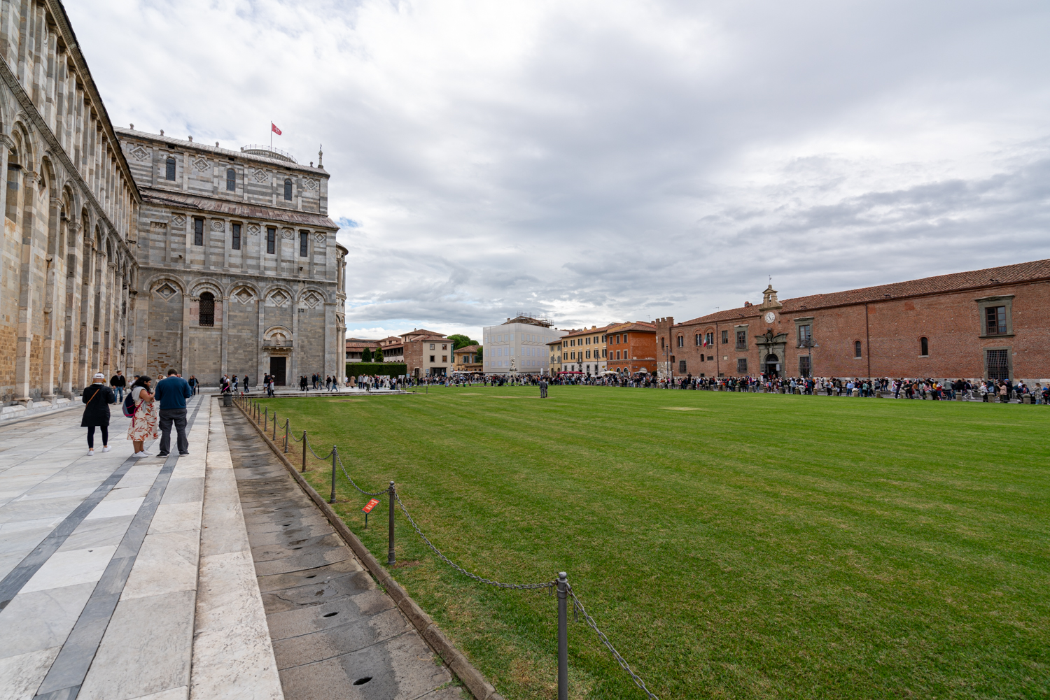 view of edge of pisa cathedral with prominent lawn to the right and sinopie museum in the background